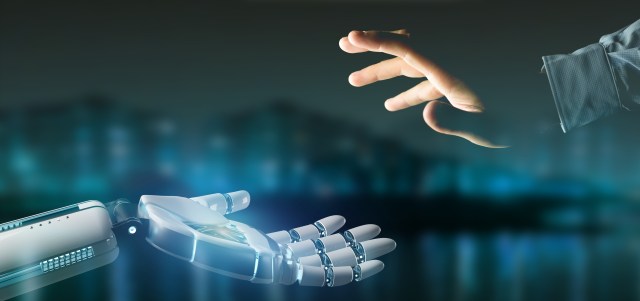 A robot hand on the left reaches towards a human hand on the right, with a blurred blue-black cityscape in the background